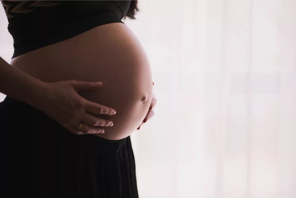 Gestante com mão na barriga. Foto de freestocks, Unsplash.
